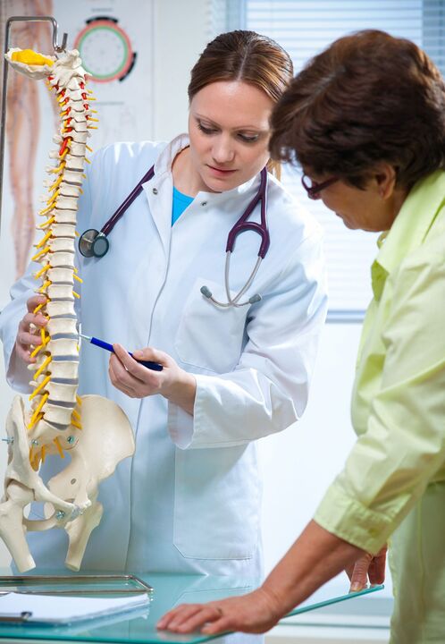 lekár demonštruje osteochondrózu chrbtice na makete
